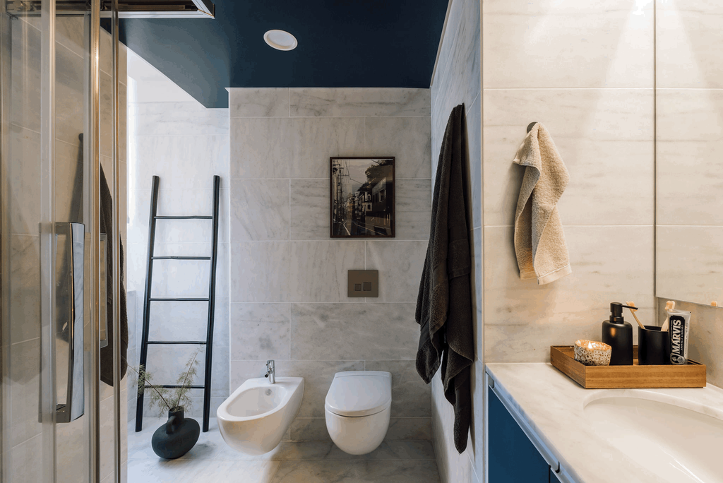 a bathroom with blue walls and a ladder. Painted ceiling, marble walls and floors, bathroom decoration, interior staging. Bathroom vase. Bathroom towels. Zara home setting. by Aptó interiors Kelly Wearstler, Noelle Baartmans