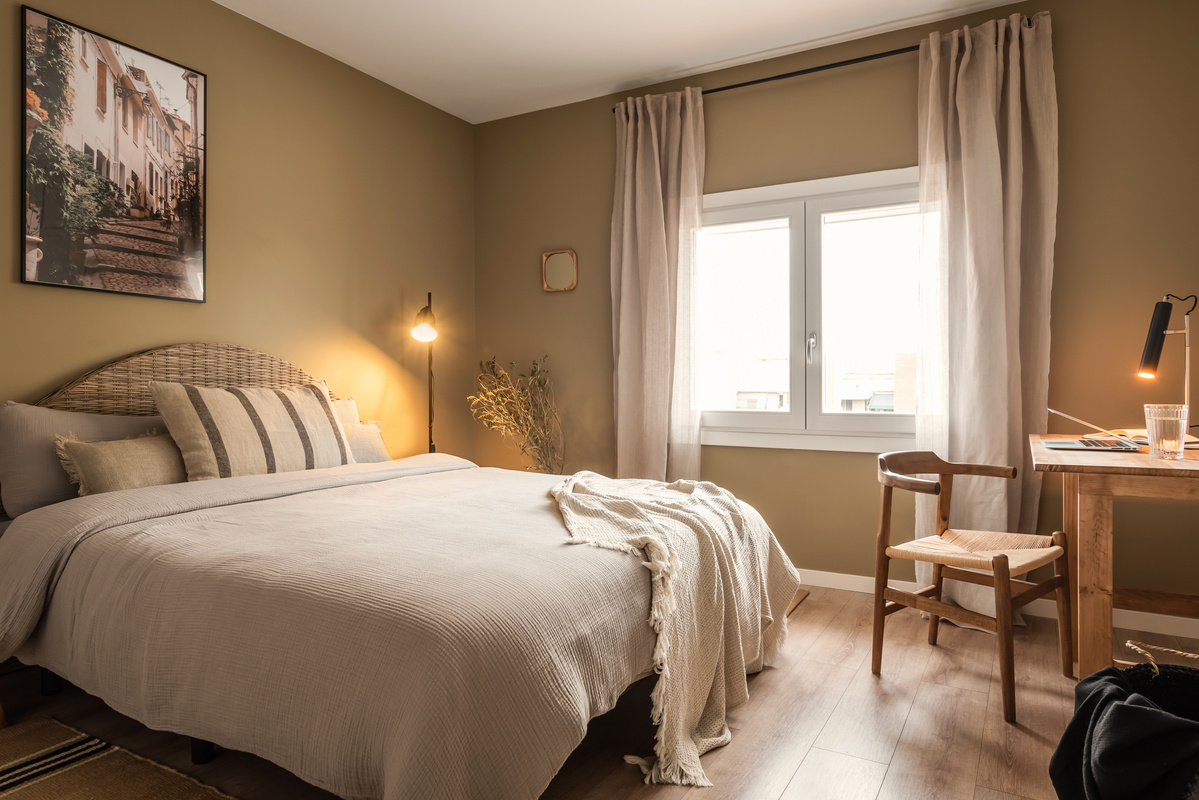 Bedroom with bed, chair and desk. A big photo frame above the bed with a picture. Linnen bedsheets, zara home pillows, organic home design, striped pillows. By Aptó interiorsBarcelona, Amsterdam. Noelle Baartmans, Kelly wearstler, interior design