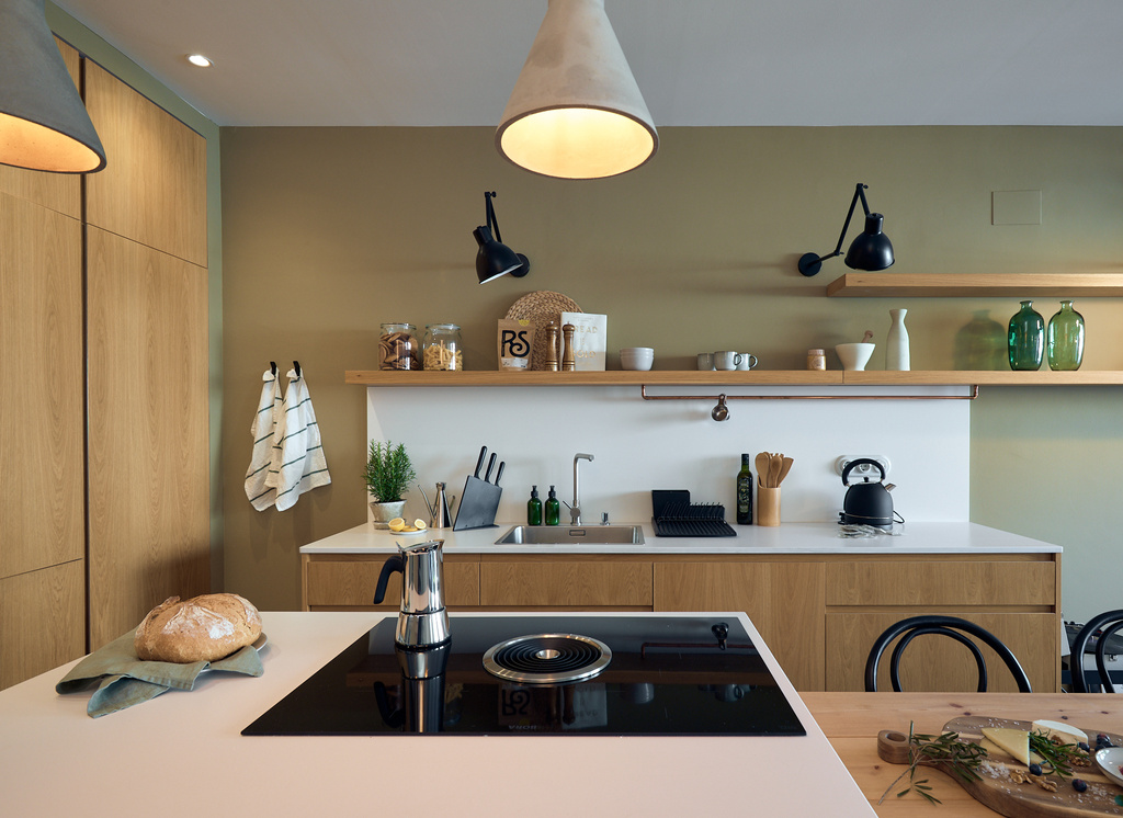a kitchen with white counter tops and wooden shelves. Organic kitchen design, zara home kitchen, wooden kitchen cabinets, kitchen decoration, kitchen design, green walls, beige walls, modern interior design, cozy kitchen. Design by Aptó interiors.
