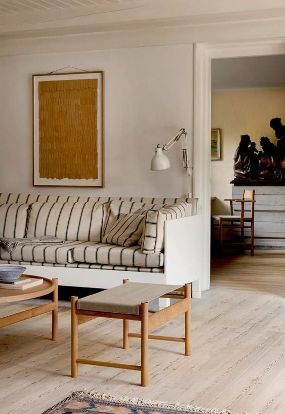 a living room with white walls and wooden floors. Beach home design, interior design help, what does an interior designer costs? expats moving to Barcelona, looking for a home in Barcelona, Aptó interiors